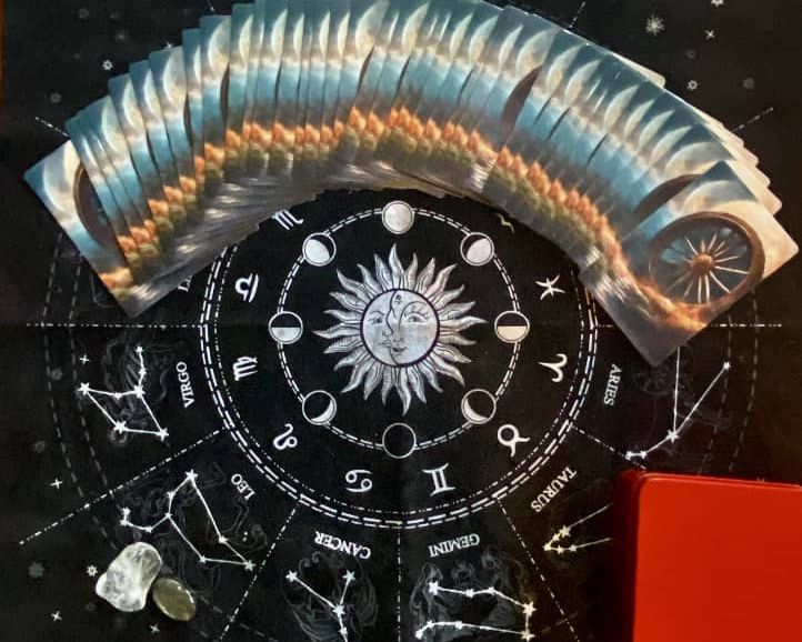 Cartas de Baralho Cigano abertas sobre uma toalha com mandala astrológica